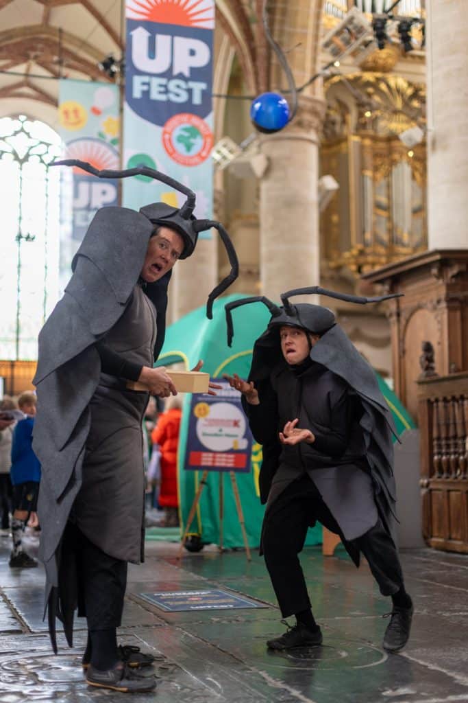 Twee acteurs verkleed als pissebed tijdens UPfest in de Grote Kerk in Alkmaar.