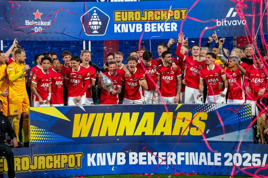 Een groep voetballers van AZ staat op een podium en houdt de KNVB Beker in de lucht