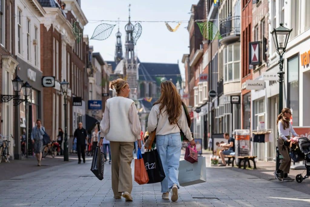 Twee winkelende mensen lopen door de Langestraat in Alkmaar.