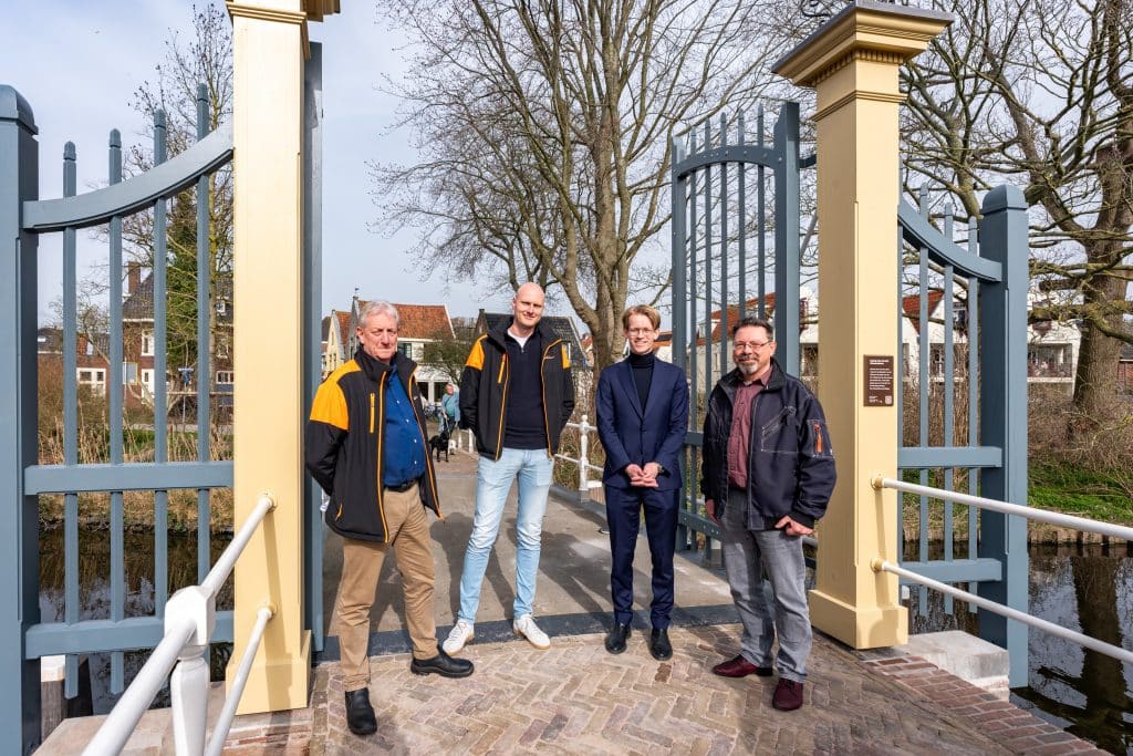 Vier mannen staan bij het nieuwe Nieuwlanderhek op de Popmansbrug in Alkmaar.