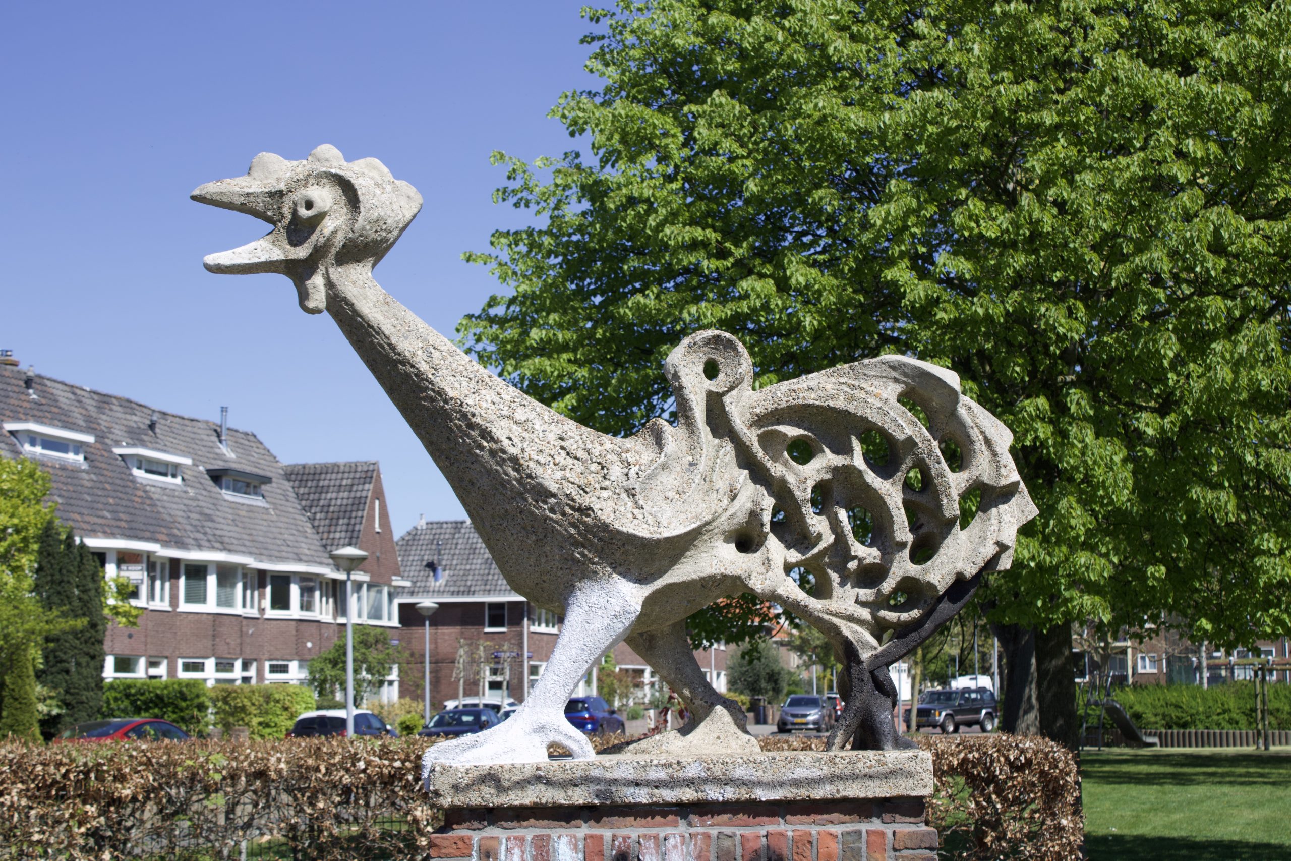 standbeeld, haan van beton op bakstenen sokkel