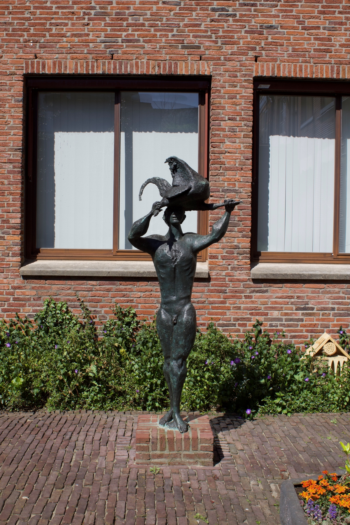 beeld van man met een haan, in brons
