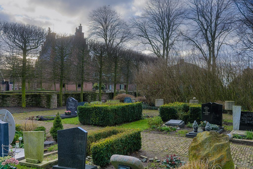 een foto van de begraafplaats in graft, met de kerk op de achtergrond