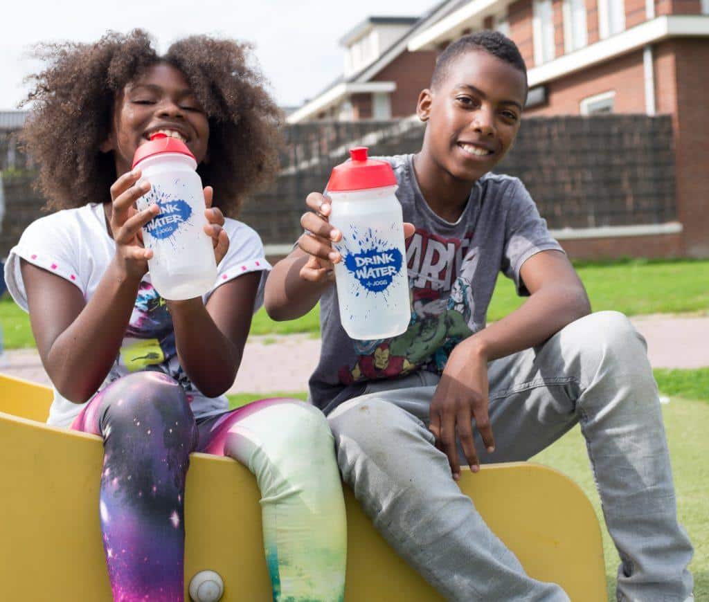 twee kinderen zitten buiten met hun waterflessen