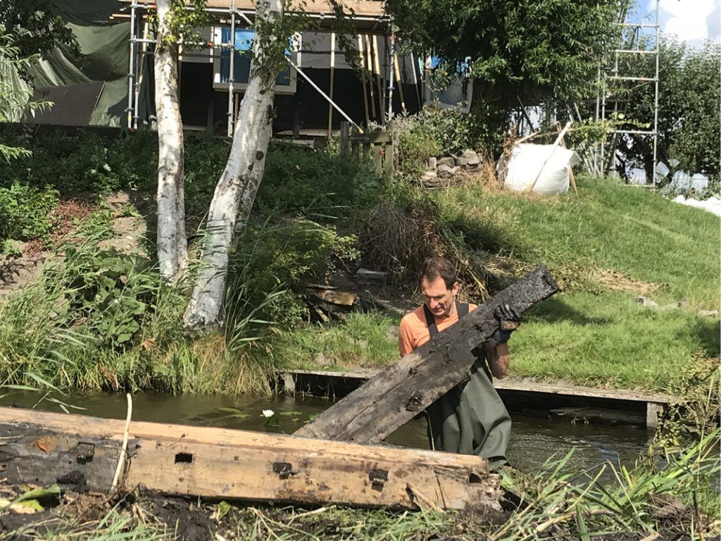 Bij het baggeren van de sloot kwam Jan Ernst delen tegen van de houten roeden van de voormalige molenwieken.