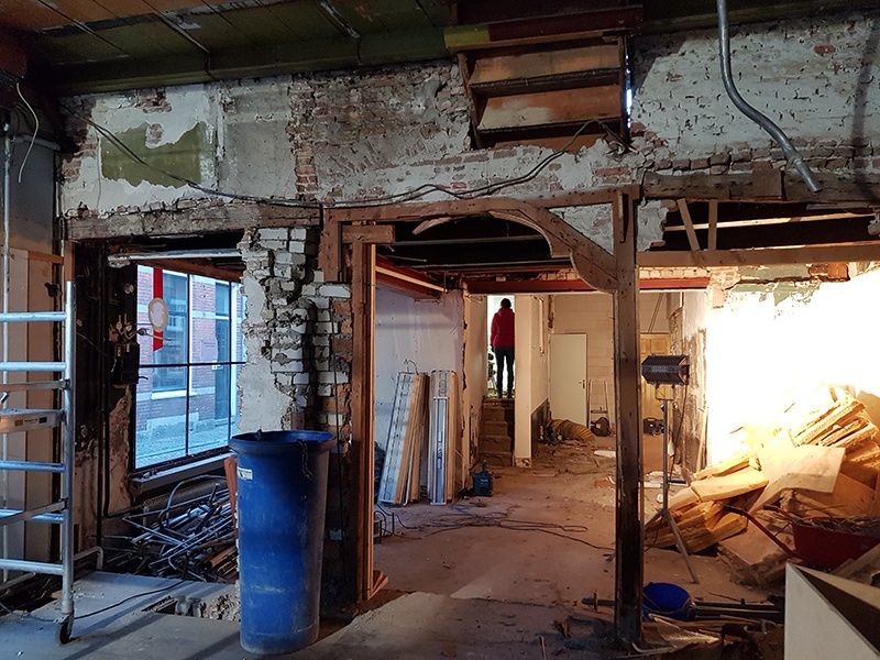 Het interieur van de voormalige winkel, met een merkwaardige houtconstructie die de muur van het tweede huis achter Verdronkenoord 121 opvangt. Boven de doorgang een oude ontlastingsboog in het metselwerk van circa 1600