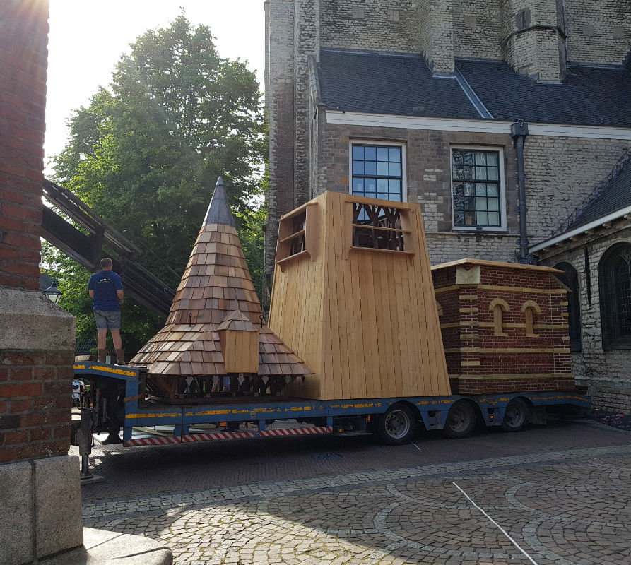 In drie delen wordt de klokkentoren vervoerd van het Waagplein naar de Grote Kerk