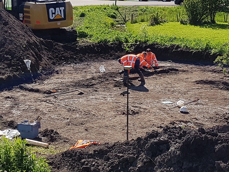 Opgraving van 17de-eeuwse huisresten op een erf van Wouthuyse, met op de achtergrond de pont van De Woude (vanuit het noordoosten)