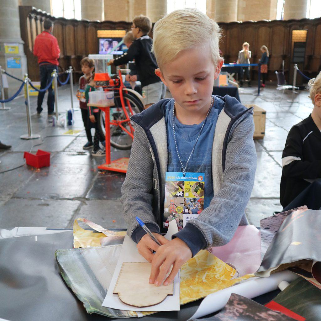 Portemonneetjes maken bij de jeugdafvalmarathon in de Grote Kerk