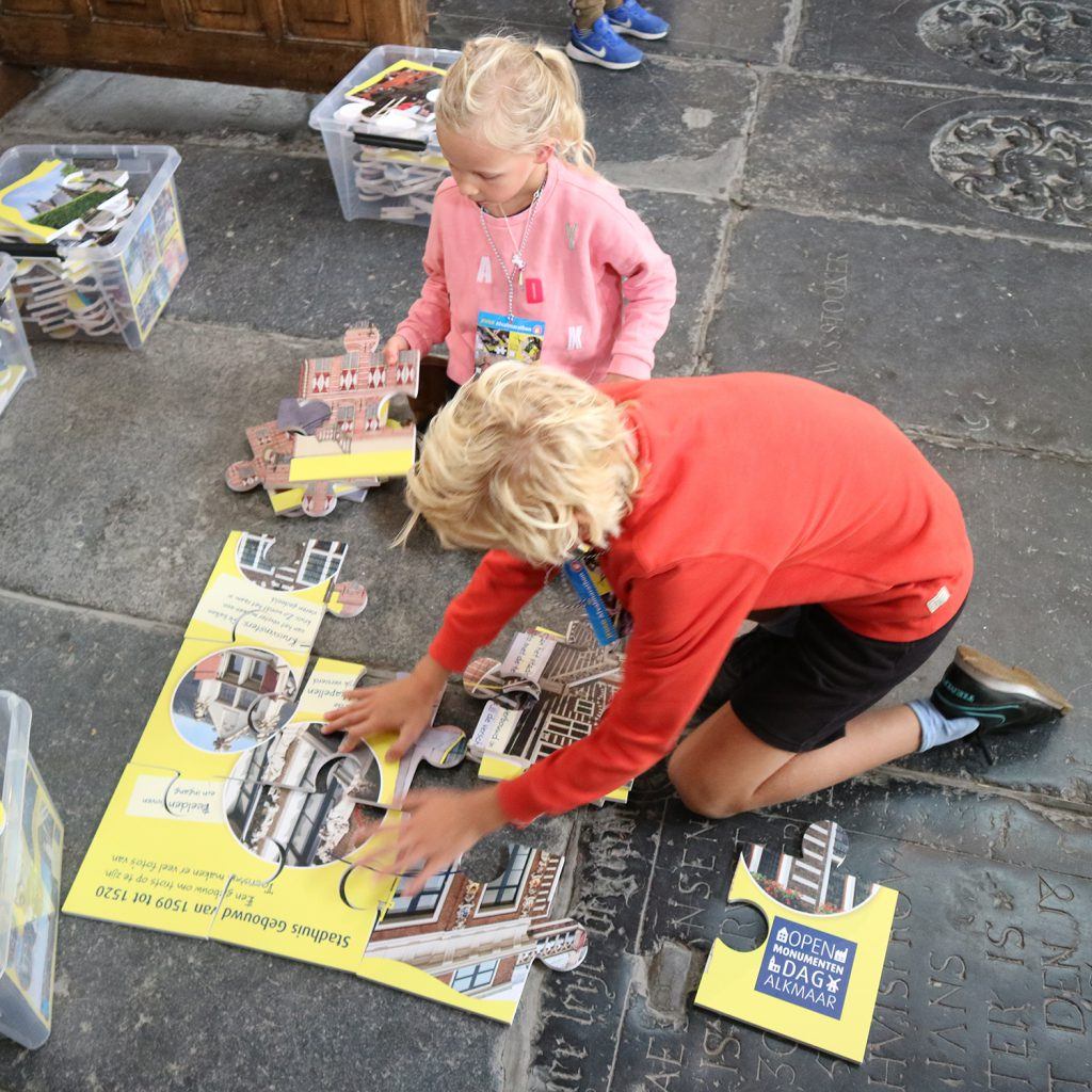 Reuzenpuzzels leggen bij de jeugdafvalmarathon in de Grote Kerk