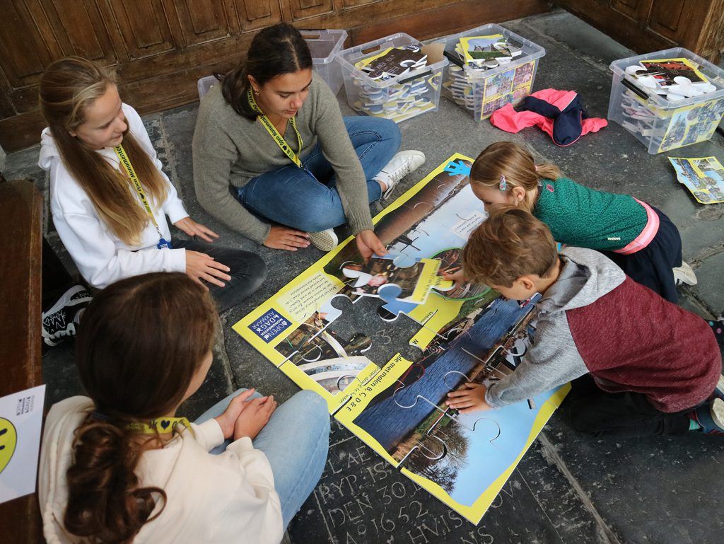 Reuzenpuzzels leggen bij de jeugdafvalmarathon in de Grote Kerk