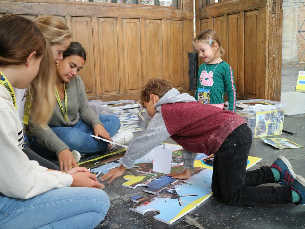 Reuzenpuzzels leggen bij de jeugdafvalmarathon in de Grote Kerk