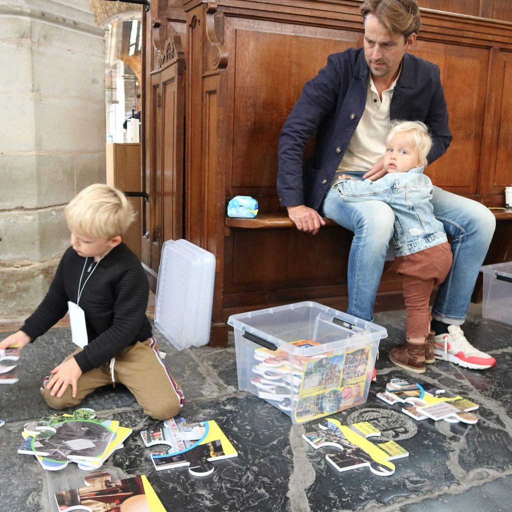 Reuzenpuzzels leggen bij de jeugdafvalmarathon in de Grote Kerk