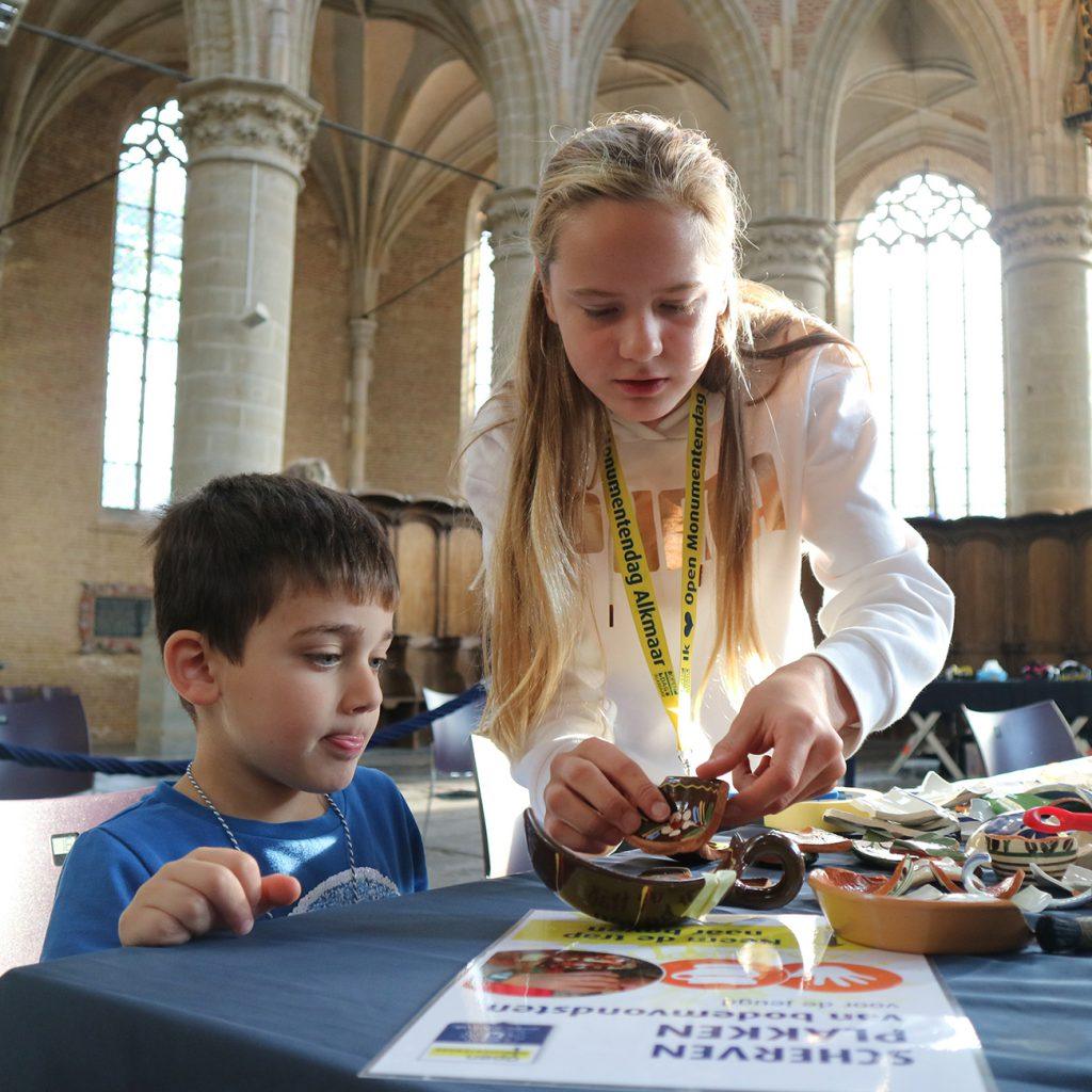 Scherven plakken bij de jeugdafvalmarathon in de Grote Kerk