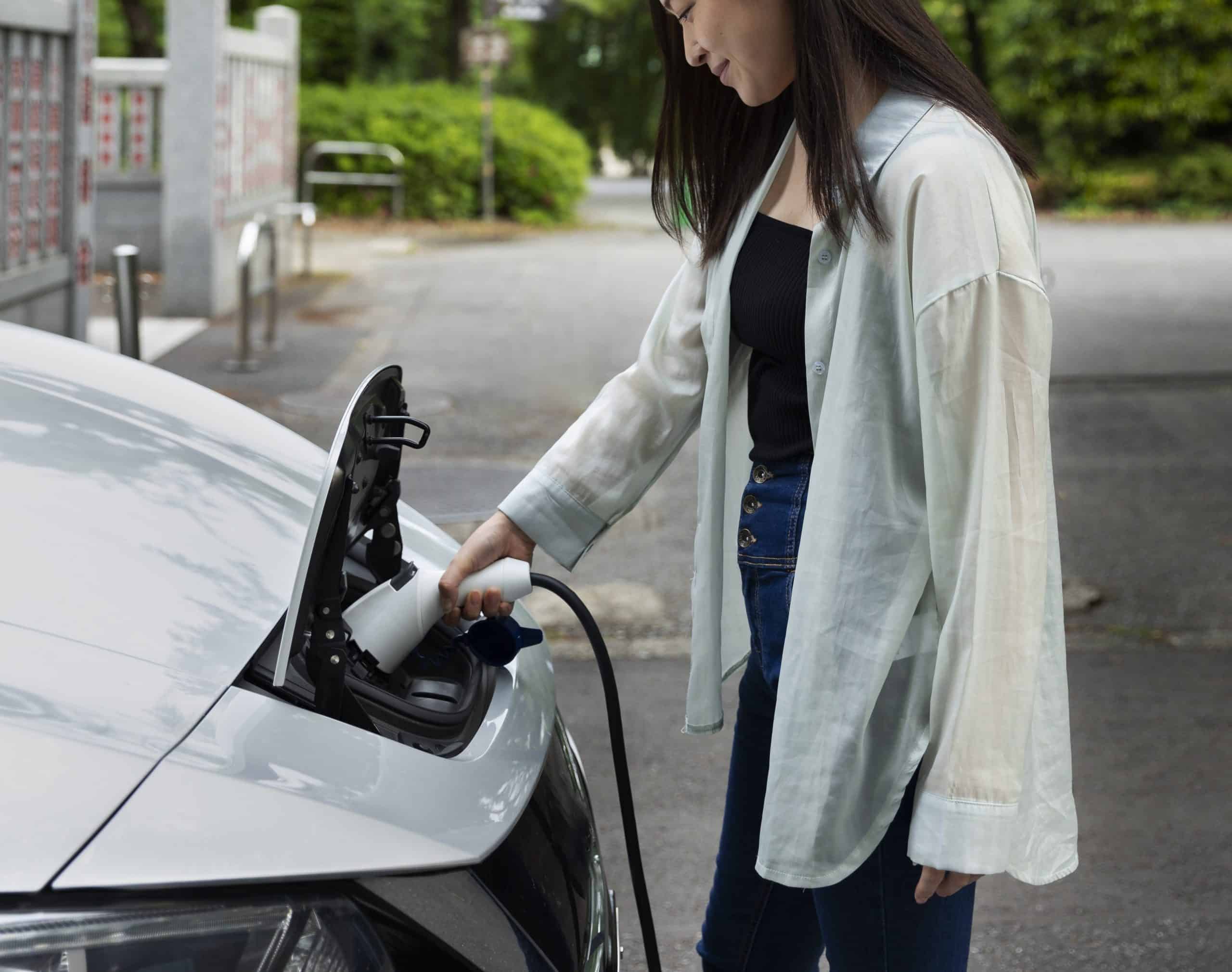 Vrouw laadt auto op.
