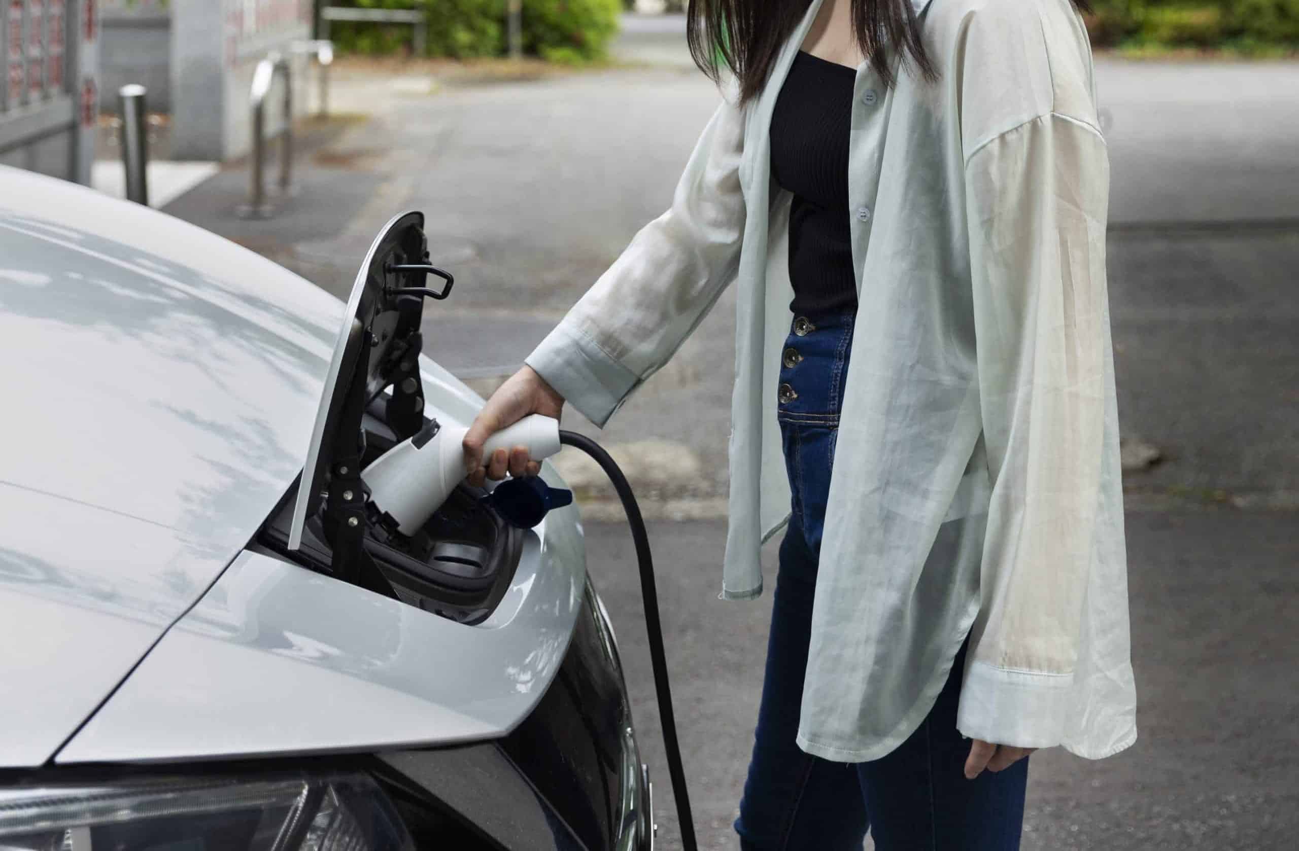 Een vrouw laadt haar auto op