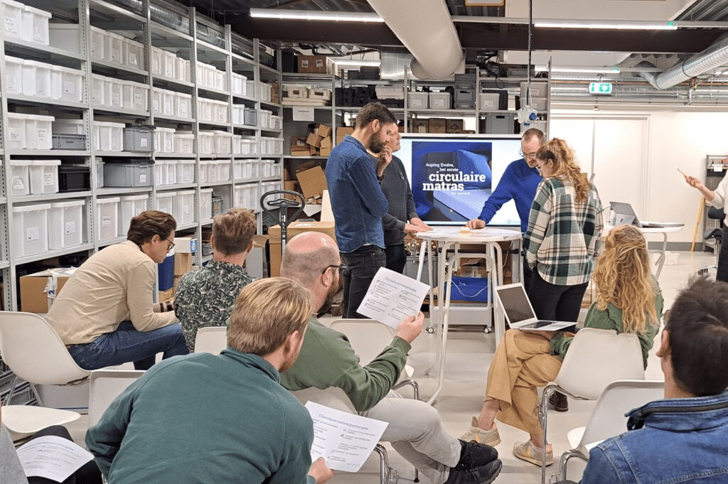 Medewerkers kijken naar een iemand die iets op een scherm presenteert