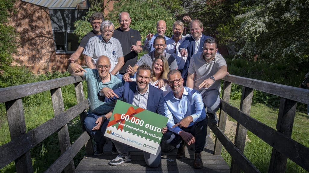 Groep blije ondernemers op een bruggetje poseren met een cheque ter waarde van 60.000 euro.